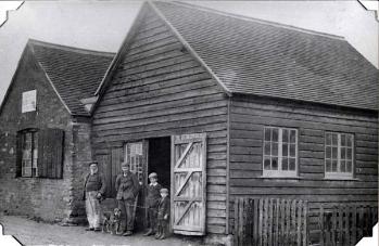 William Prudden and family standing outside the smithy [Z50/21/23]
